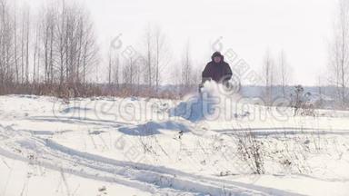 穿着<strong>冬季服装</strong>的成年男子骑着小雪车在雪地里快速跳跃，拖着拖车停下来